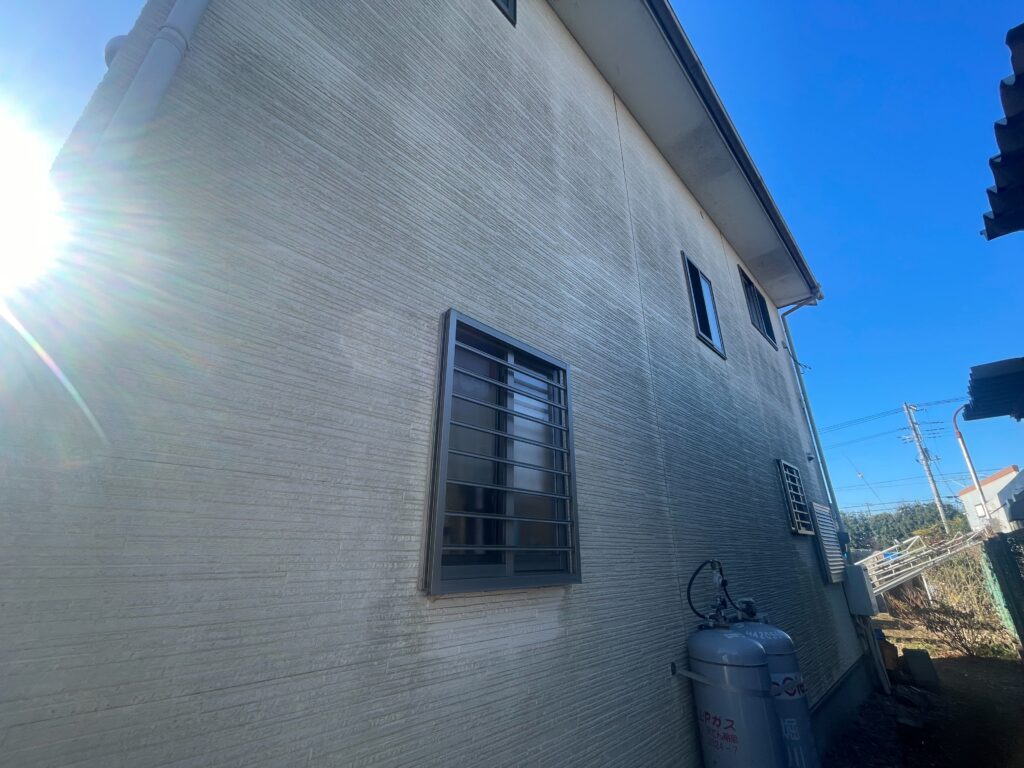 家の背面は日が当たりづらいため、塗膜が剥がれ、外壁全体に苔が発生して広がっています。